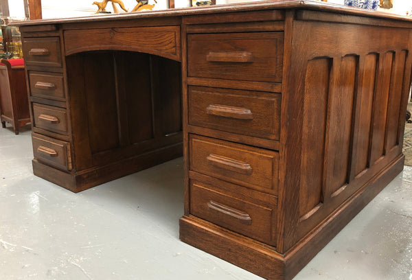 Lovely large English oak partners desk, with a beautiful burgundy tooled leather top. Plenty of storage space, both sides have 9 functioning drawers. It is in very good condition.
