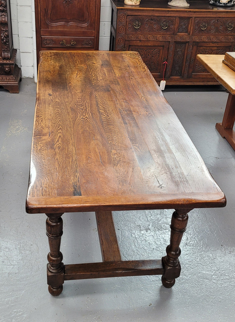 Rustic French Oak stretcher based farmhouse dining table that comfortably seats 6-8 people. It has been sourced from France and is in good original condition.