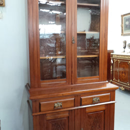 A beautiful Edwardian walnut stained bookcase with lovely carved doors and adjustable shelves. It is 227 cm tall and in very good fully restored condition.