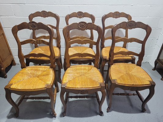 Set of six French Louis 15th style rush seated dining chairs. They are comfortable to sit in and are in original condition.