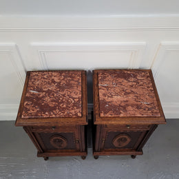 Pair of French Art Deco Oak and rouge inset marble top bedside cabinets. They have one drawer and one cupboard with elegant carving on the door. They have been sourced from France and are in good original detailed condition.