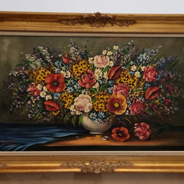 Sourced from France a stunning colorful floral oil painting on canvas. It is in a decorative gilt frame and is signed. It is in good original detailed condition.