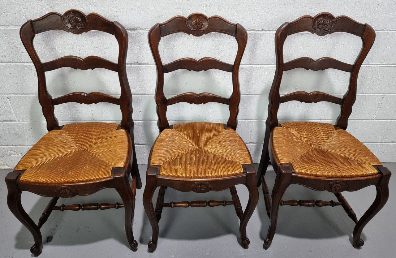 Set of six French dark Oak rush seat dining chairs with ladder back. They are in good detailed original condition and very comfortable to sit in.