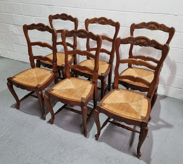 Lovely set of six French oak rush seated provincial dining chairs. They have been sourced from France and are in good detailed condition.