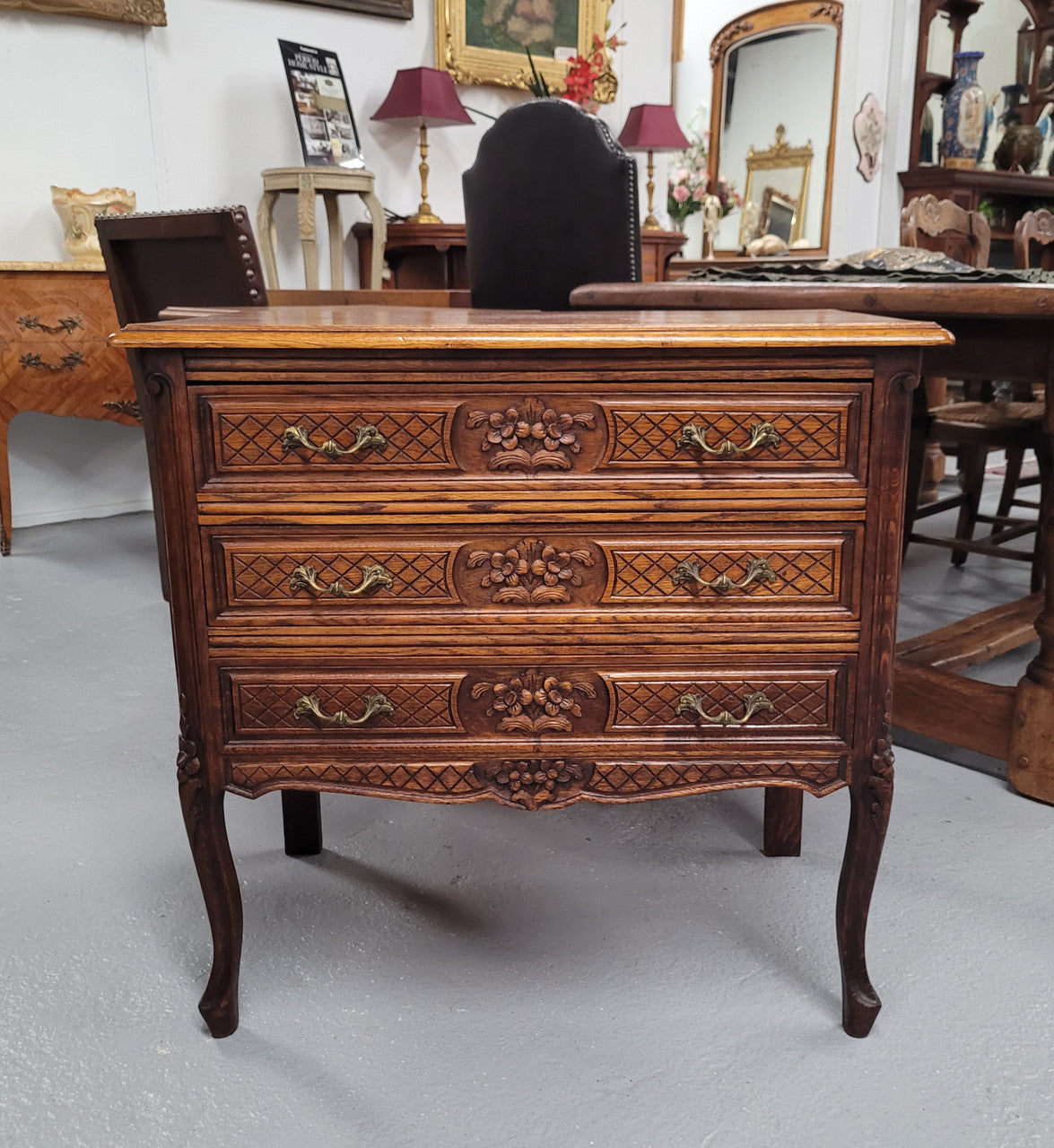 Rustic Louis XV style Oak petite three drawer chest featuring attractive carvings. It has been sourced locally and it is in good original detailed condition.