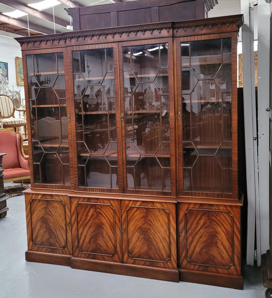 Georgian style Breakfront Flame Mahogany four door bookcase. A very impressive piece with plenty of storage and is of pleasing narrow proportions. It has been sourced locally and is in good original detailed condition.