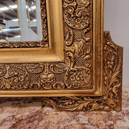 French ornate gilt decorated and floral bevelled mirror. It has been sourced from France and it is in good original condition.
