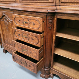 Impressive French Oak Louis 14th Style Display and Sideboard. It has 4 drawers, 2 bottom cupboards with 6 total shelves and 3 display doors with 3 shelves.  In good, detailed condition.