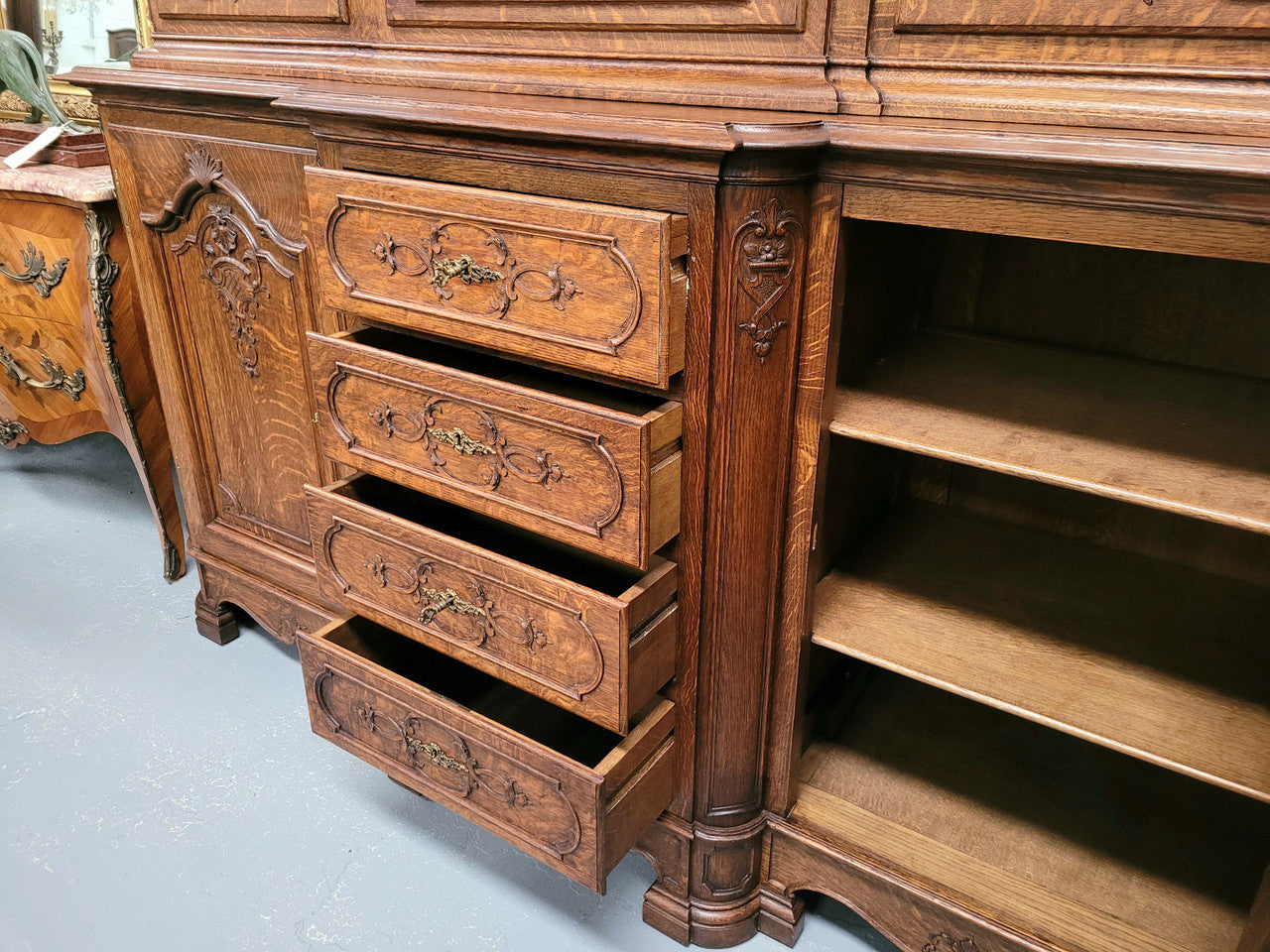 Impressive French Oak Louis 14th Style Display and Sideboard. It has 4 drawers, 2 bottom cupboards with 6 total shelves and 3 display doors with 3 shelves.  In good, detailed condition.