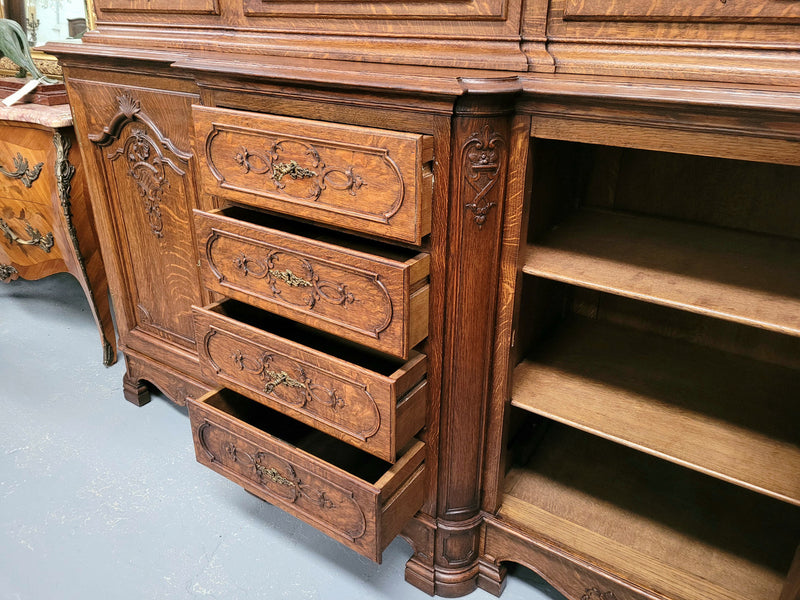 Impressive French Oak Louis 14th Style Display and Sideboard. It has 4 drawers, 2 bottom cupboards with 6 total shelves and 3 display doors with 3 shelves.  In good, detailed condition.
