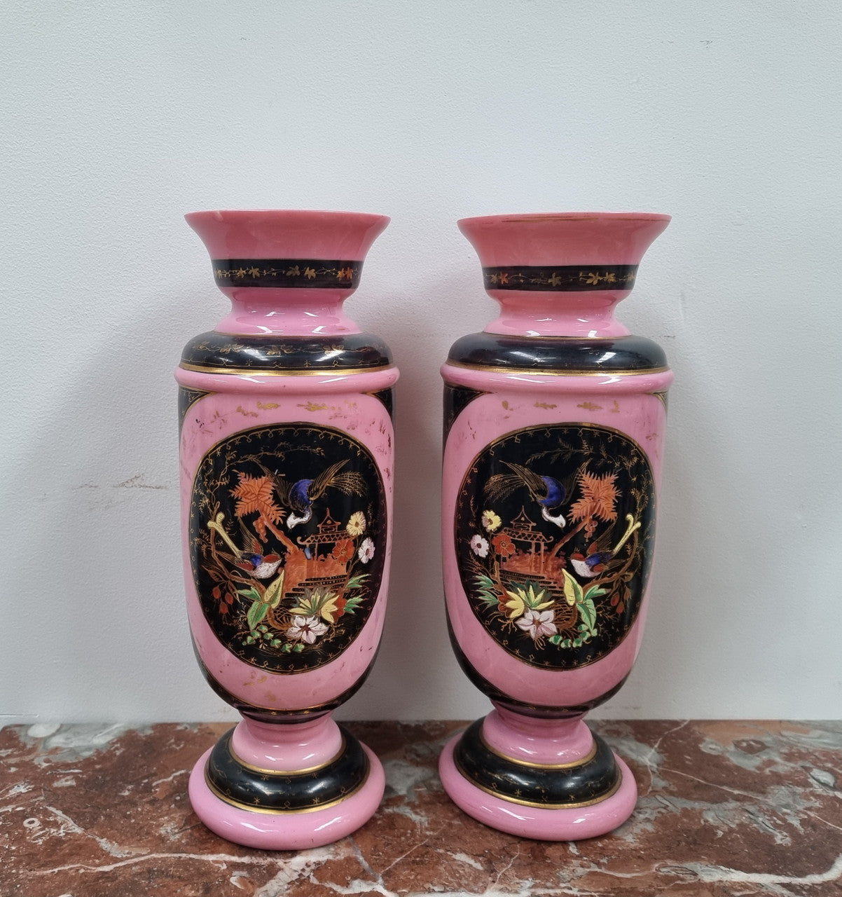 Late Victorian pink and hand painted, enameled pair of vases with some ware to enameling. It is in good original condition.