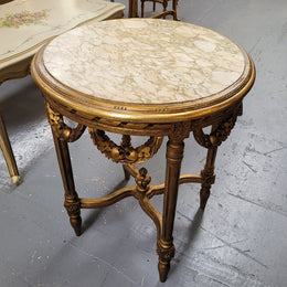 French Louis XVI style round marble topped gilded lamp/side table featuring lovely carved swags and undercarriage. It has been sourced from France and is in good original detailed condition.