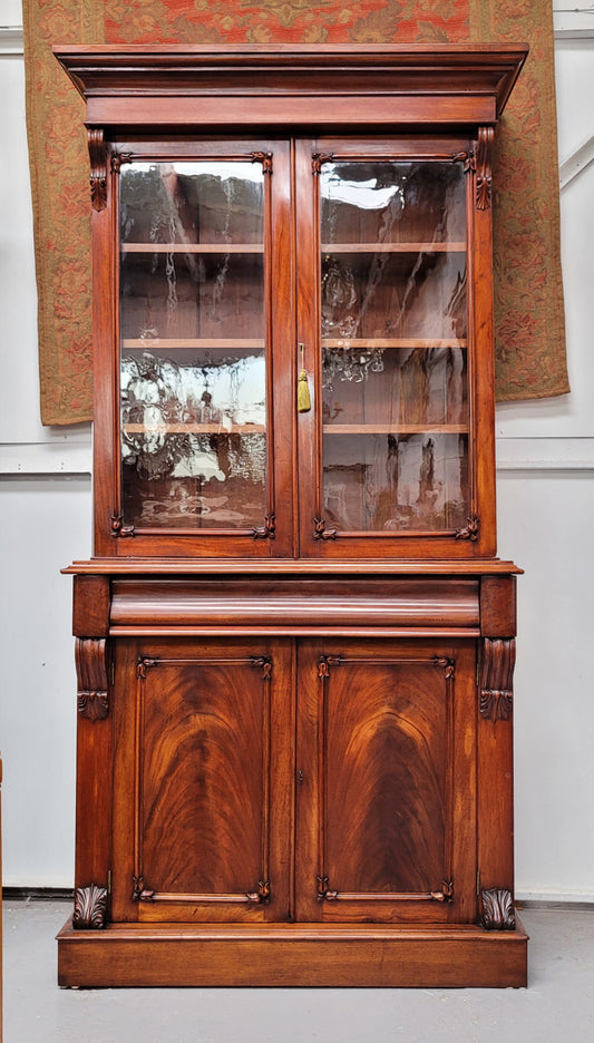 Mid 19th Century Australian Cedar and Flame Cedar tall bookcase. The top has two glass doors that open up to three adjustable shelves followed by a drawer in the middle and finishes with two beautiful wooden doors that open up to a fixed shelf. In good original detailed condition and has been sourced locally.