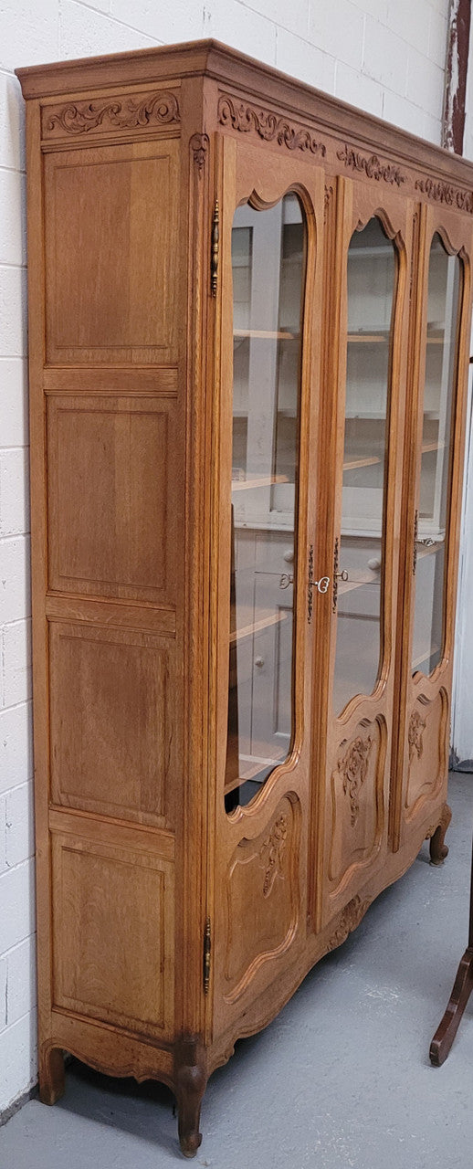 French Louis XV style light Oak three door bookcase with five fixed shelves. It has lovley glass doors and has been sourced from France. Is in good original detailed condition