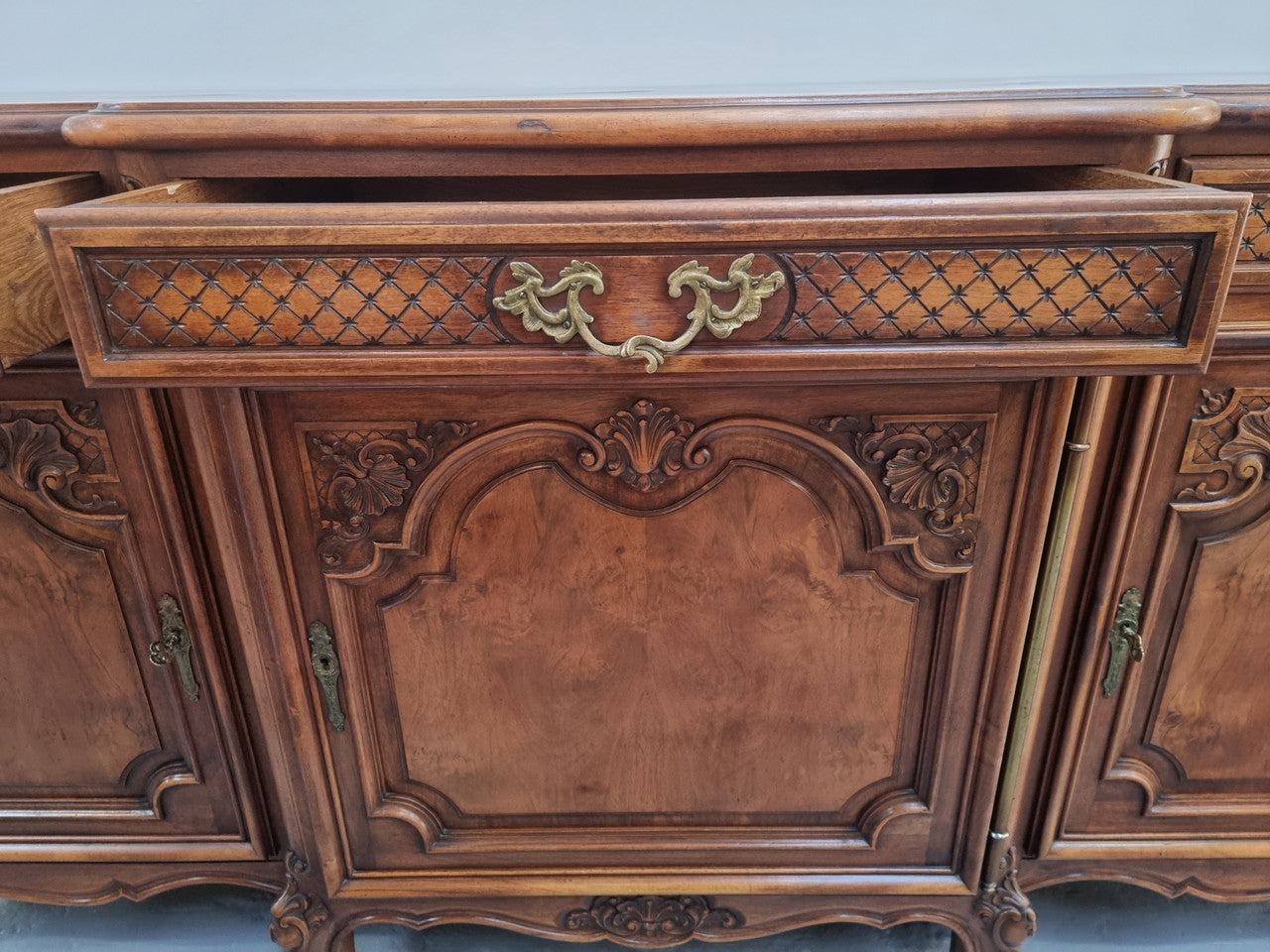 French Burr Walnut/Walnut parquetry top three door and three drawer sideboard. Plenty of storage space and beautiful decorative carvings. In good original detailed condition.