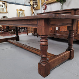 Charming solid rustic Oak stretcher base Farmhouse table. The table is circa 1950's and was custom made using reclaimed oak. It comfortable sits eight and could seat 10. It is in good original detailed condition.