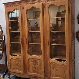 French Louis XV style light Oak three door bookcase with five fixed shelves. It has lovley glass doors and has been sourced from France. Is in good original detailed condition