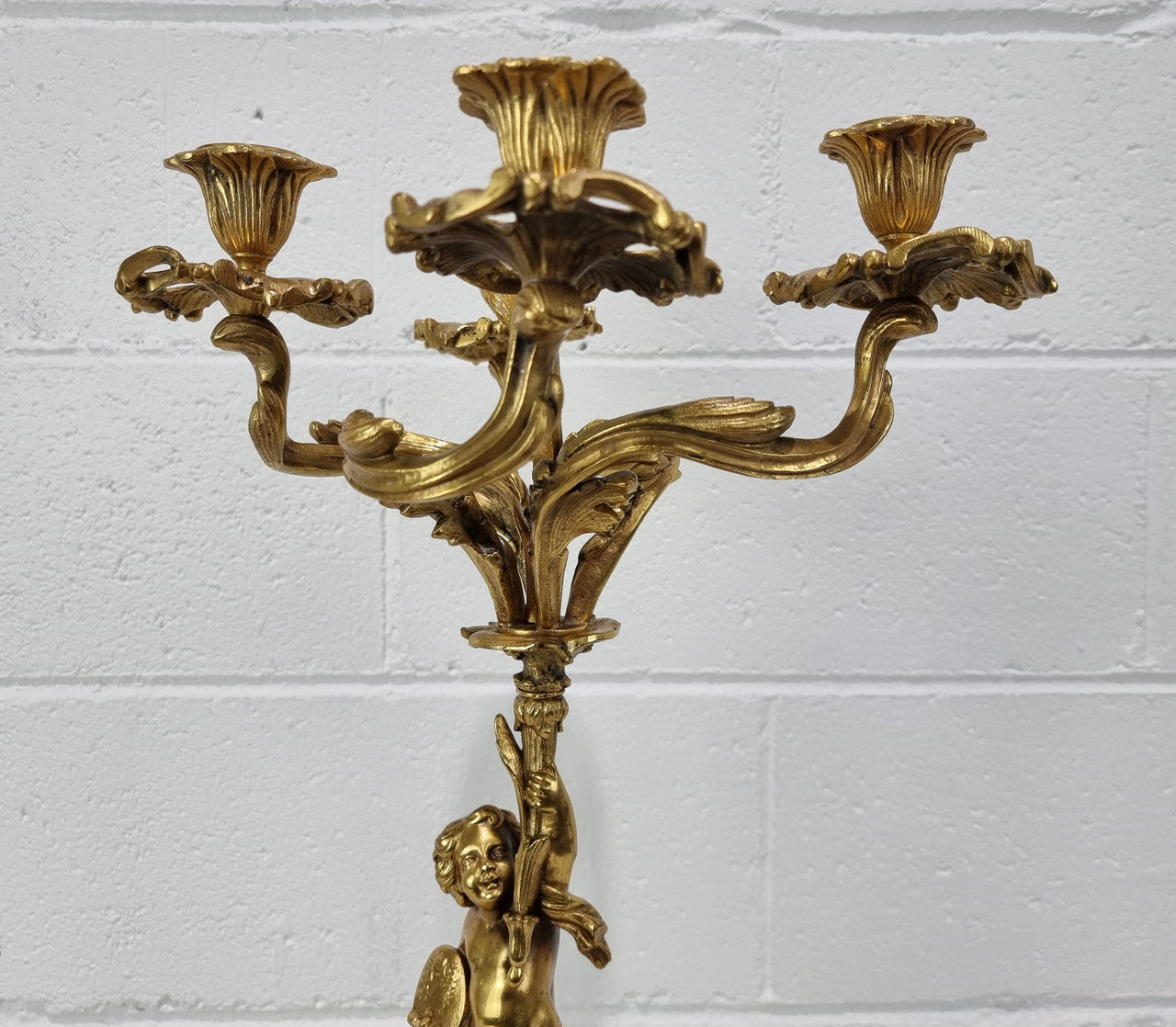 A pretty 19th Century French gilt bronze candelabra featuring a cherub. In good condition. Circa 1880.