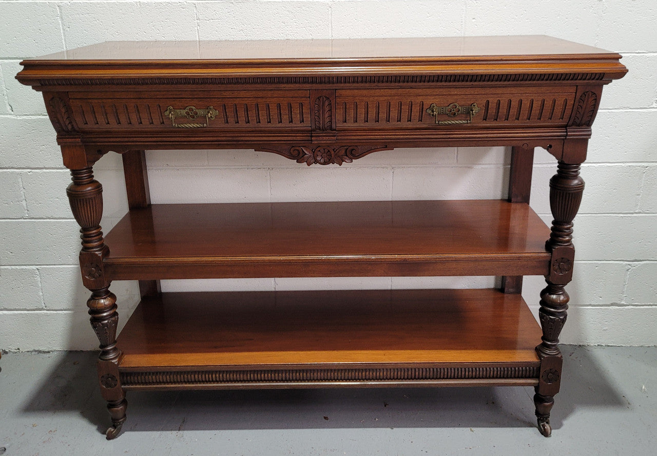 Fabulous quality Edwardian Walnut dumb waiter. It has two drawers and two shelves and is on casters. In good original detailed condition.