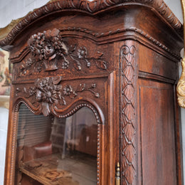 Petite oak armoire display cabinet with a glass door, two drawers at the bottom and three shelves inside. Late 18th Century and amazing detailed decorative carvings. Sourced from France and in good original condition.