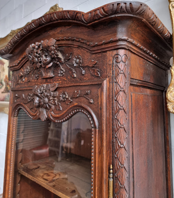 Petite oak armoire display cabinet with a glass door, two drawers at the bottom and three shelves inside. Late 18th Century and amazing detailed decorative carvings. Sourced from France and in good original condition.