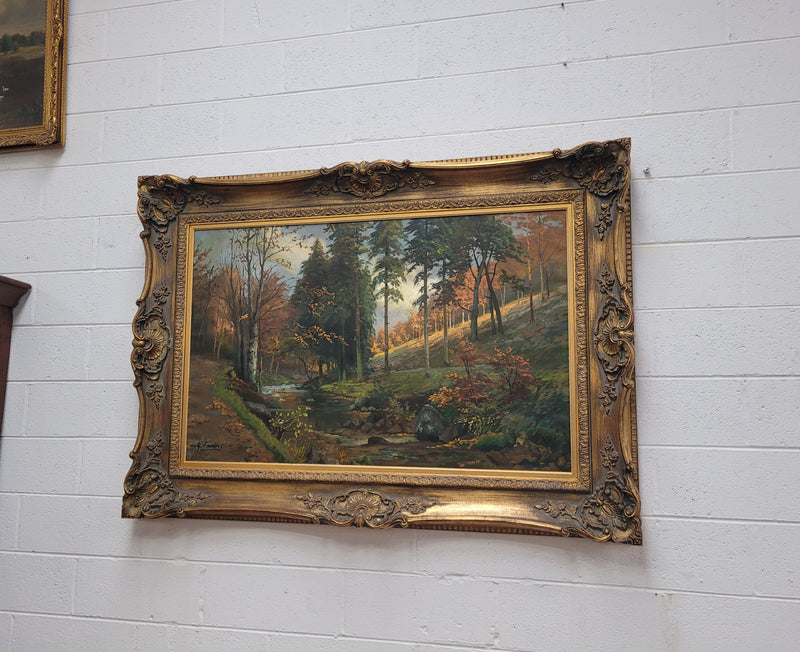Large signed oil on canvas depicting a river stream in autumn framed in a stunning gilt frame. Sourced from France and is in good original detailed condition.