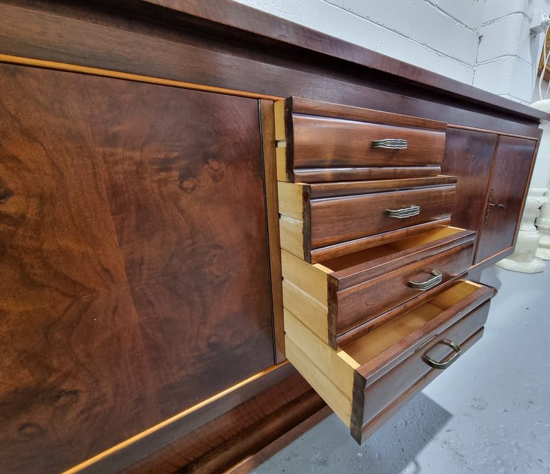 Amazing French Walnut Art deco four door buffet. The doors either side open to a fixed shelf and plenty of added storage with four drawers. In good original detailed condition.
