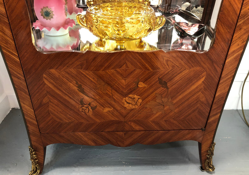 A Louis XV style Kingwood vitrine with marble top. It has beautifully floral inlay with ormolu mounts.