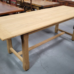 French raw Oak stretcher based refectory table. Features raw wood that could be used as is for a distressed look, or finished and waxed for a more refined look. Sourced from France and in good original condition.