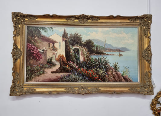 Sourced in France a colorful signed oil on canvas " Mediterranean coastal scene" in a decorative gilt frame. It is in good original detailed condition.
