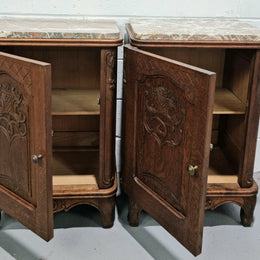 Lovely pair of French oak bedside cabinets with nicely carved details and marble tops. In good original detailed condition.