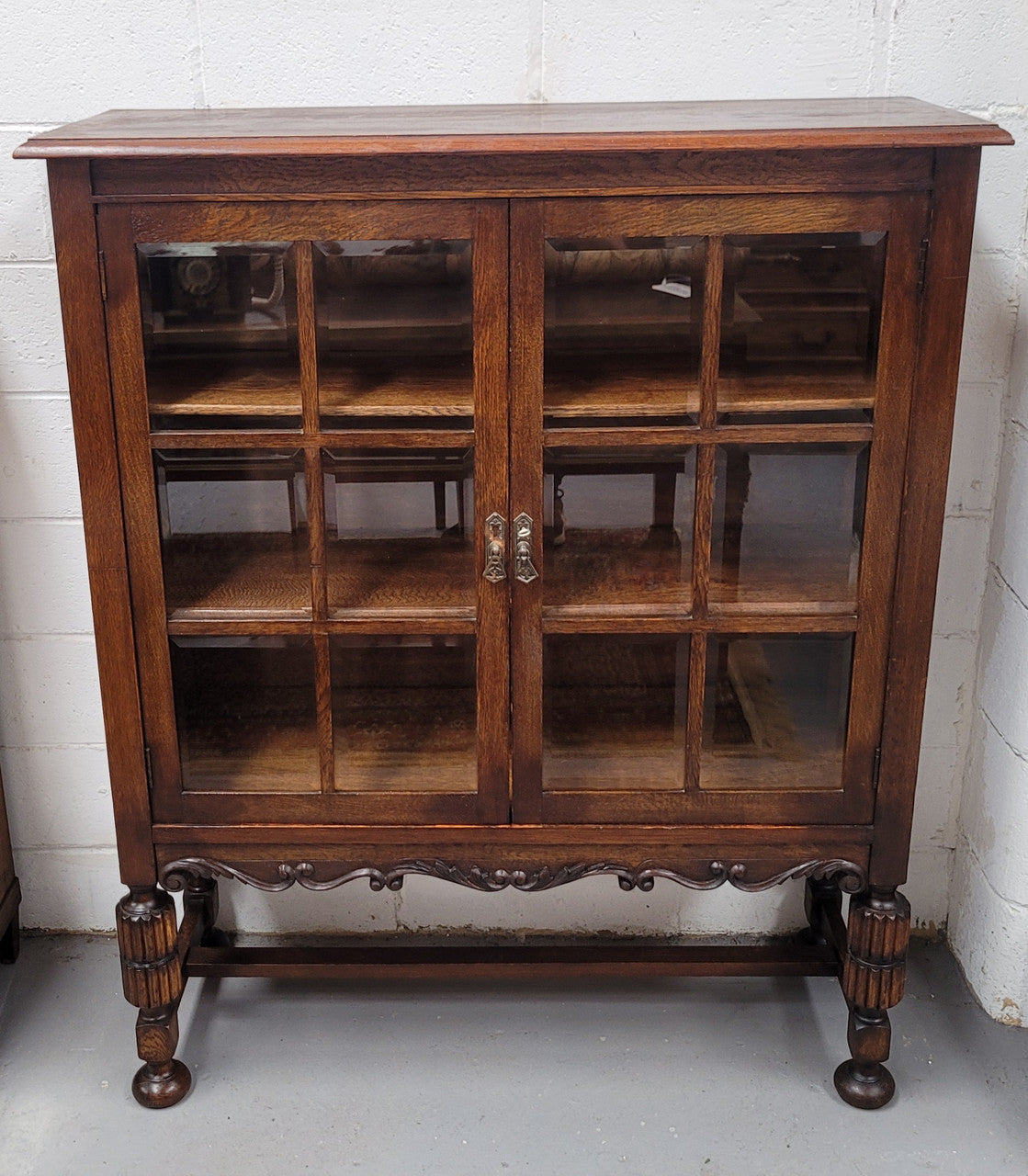 Tudor oak 2 door astral glaze and beveled glass bookcase.  Good original condition. Circa 1930s.