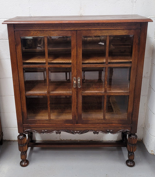 Tudor oak 2 door astral glaze and beveled glass bookcase.  Good original condition. Circa 1930s.