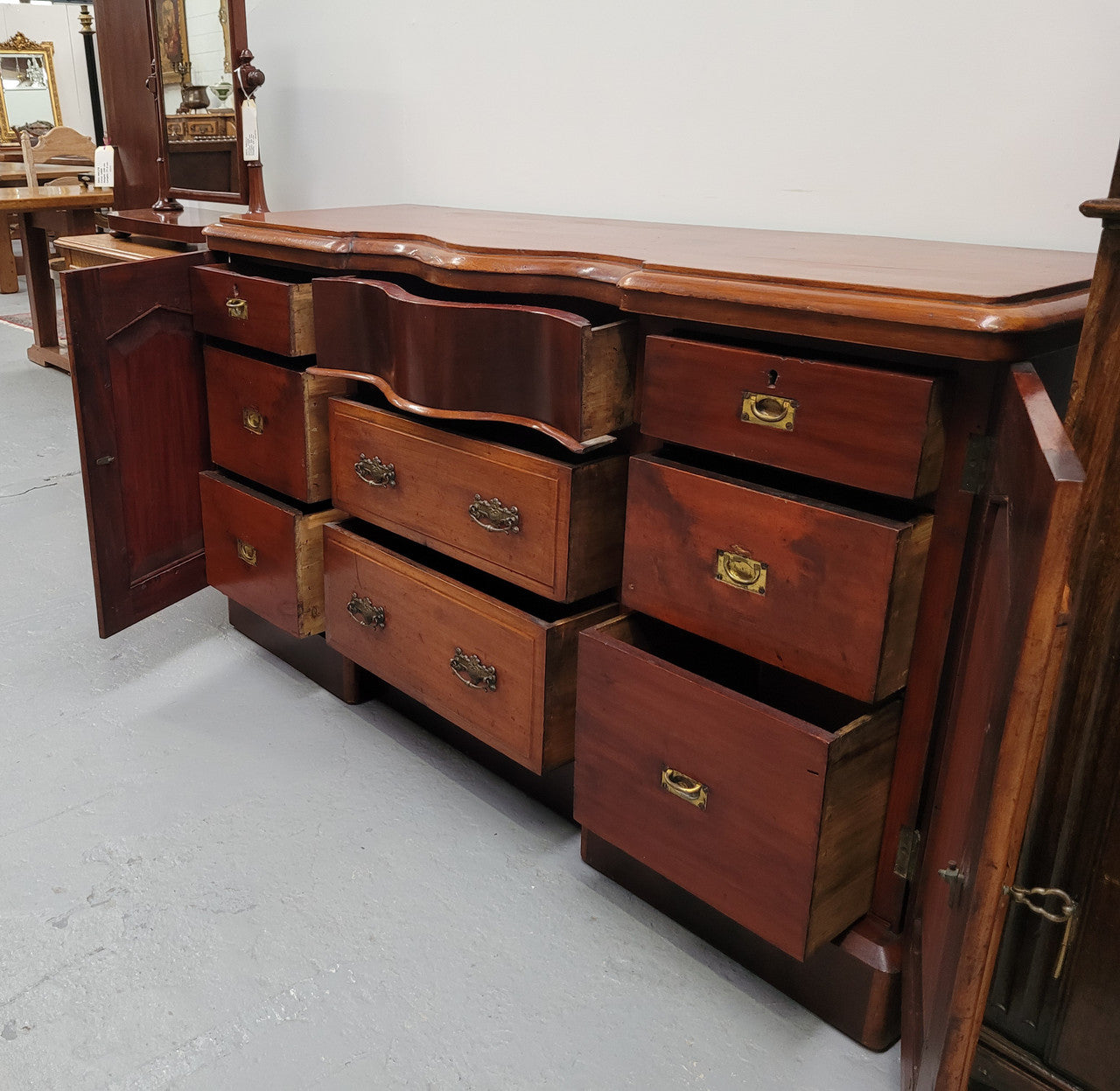 An English Victorian Mahogany sideboard with nine drawers. This amazing piece has loads of storage with three central drawers in the middle and a further six drawers. It has three each side located behind two doors. It has been sourced from locally and in original detailed condition.