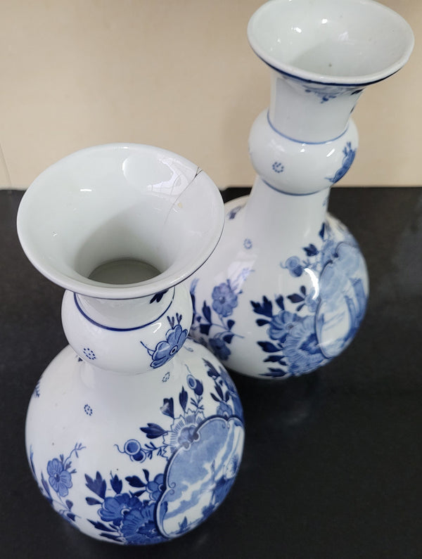 Pair of Victorian delft blue hand painted vases. Stamped underneath and one featuring a ship scene and the other a windmill scene. Please note the windmill vase does have a hairline crack at the top otherwise in good condition, please view photos as they help form part of the description.
