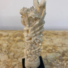 Vintage ornately carved bone ornament on stand.