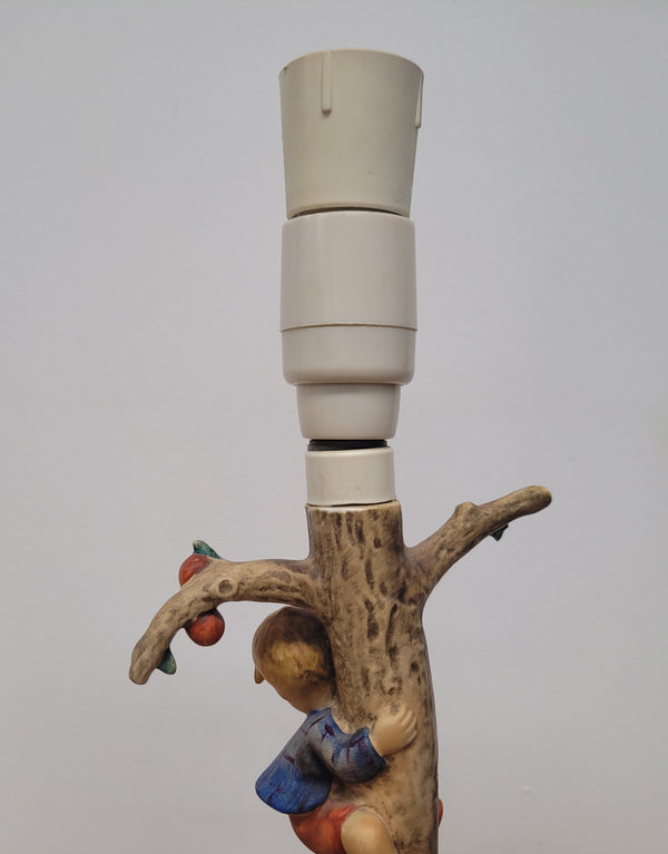 Charming Hummel Lamp featuring a young boy climbing an apple tree with a barking dog on the ground.  Incised Hummel mark on side of base and 44A on base with 1935 (copyright) and Goebel W Germany. Height without shade 33.5cm