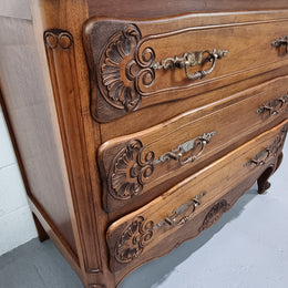 A French Walnut carved three drawer commode with lovely handles and in good original detailed condition.
