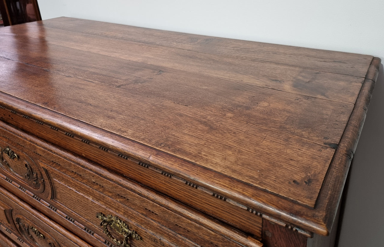 Early 19th Century French Oak chest of three drawers. It has beautiful handles and carvings. It is in good original detailed condition.
