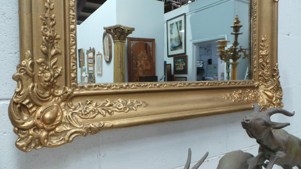 A French transitional Louis XV/Louis XVI style, gilded hanging wall mirror. In good restored condition.