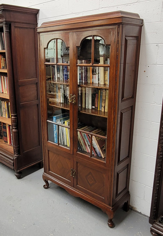 Beautiful four door Walnut bookcase with glass doors. The top section has two fully adjustable shelves and it is of pleasing narrow proportions. It is in good original detailed condition.