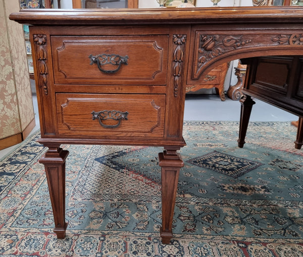 Substantial French Louis XVI style Oak partners desk. It has a beautiful leather top, two drawers on either side and decorative carvings throughout. Sourced from France and in good original detailed condition.