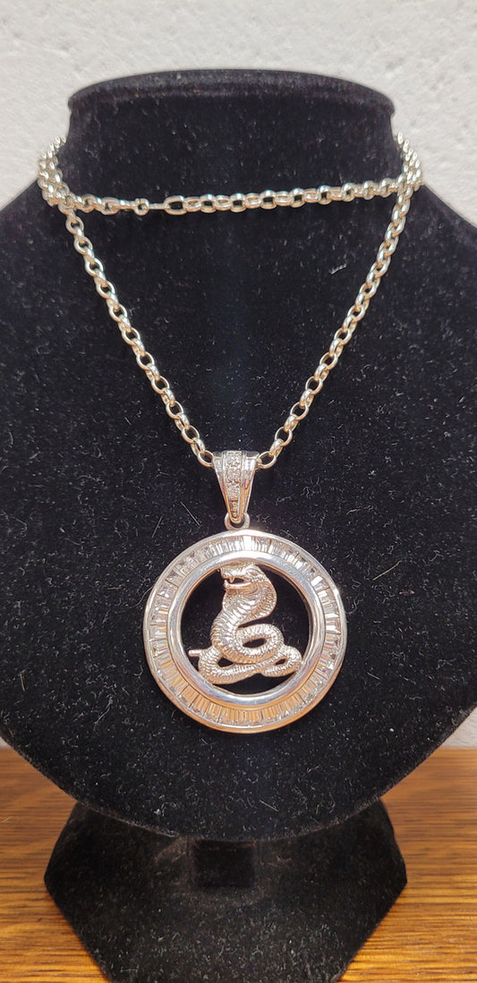 Sterling Silver pendant featuring a Cobra Snake with Cubic Zirconia surround. Heavy Bale with Cubic Zirconia. Pendant without Bale, 3.5cm Diameter. Includes 60 cm Sterling Silver Chain.