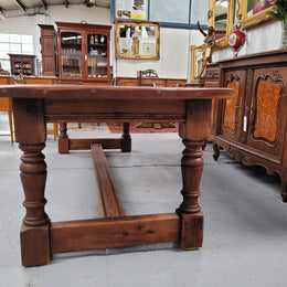 Charming solid rustic Oak stretcher base Farmhouse table. The table is circa 1950's and was custom made using reclaimed oak. It comfortable sits eight and could seat 10. It is in good original detailed condition.