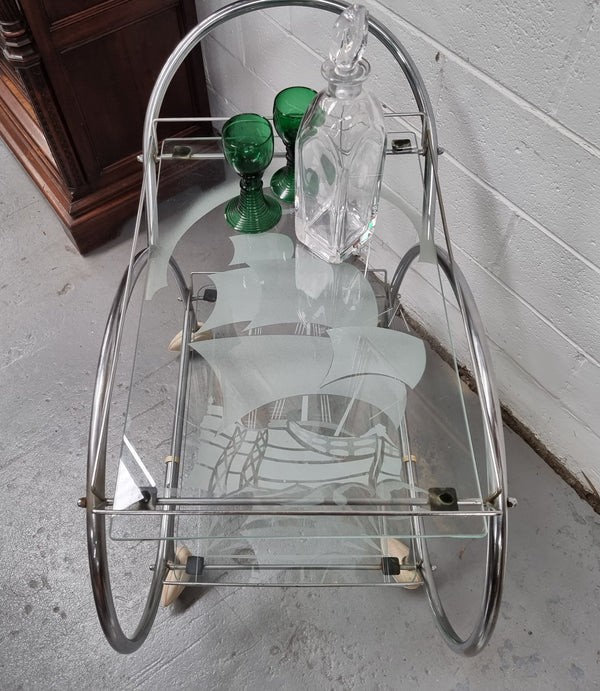 Stylish Art Deco chrome & frosted glass drinks trolley. Bakelite guards on the wheels. It is in good original condition and has been sourced locally.