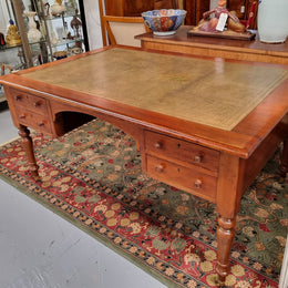 English Cedar full partners desk with attractive tooled leather top, four drawers either side and on caster wheels.  In good original detailed condition.