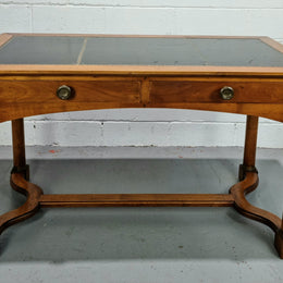 Empire style Walnut desk with pull-out slides and two drawers. It has its original gold tooled leather top and is from circa 1920's. It is in good original detailed condition.