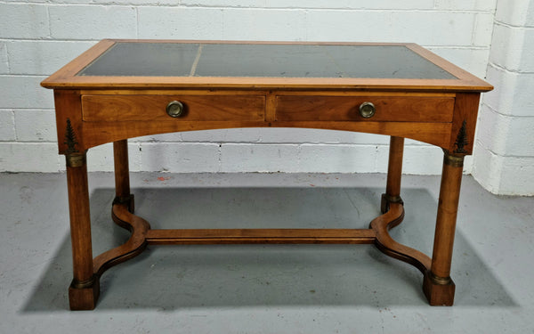 Empire style Walnut desk with pull-out slides and two drawers. It has its original gold tooled leather top and is from circa 1920's. It is in good original detailed condition.