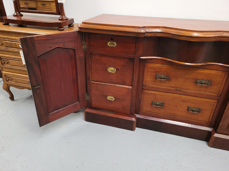 An English Victorian Mahogany sideboard with nine drawers. This amazing piece has loads of storage with three central drawers in the middle and a further six drawers. It has three each side located behind two doors. It has been sourced from locally and in original detailed condition.