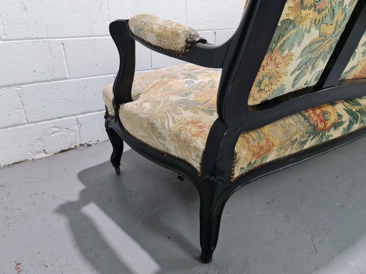 A Substantial Antique 19th Century Louis XV style ebonized serpentine front settee. The fabric is in used condition showing use and could be used as is or reupholster.